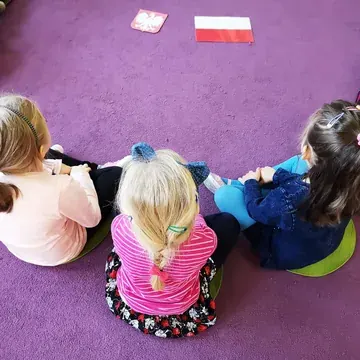 Dzieci w papierowych koronach podczas zajęć grupowych w przedszkolu